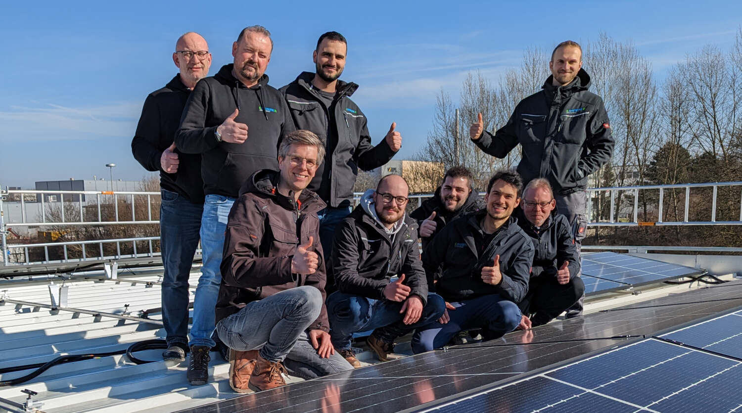 Teamfoto e.systeme21 auf Dach mit Photovoltaik-Anlage